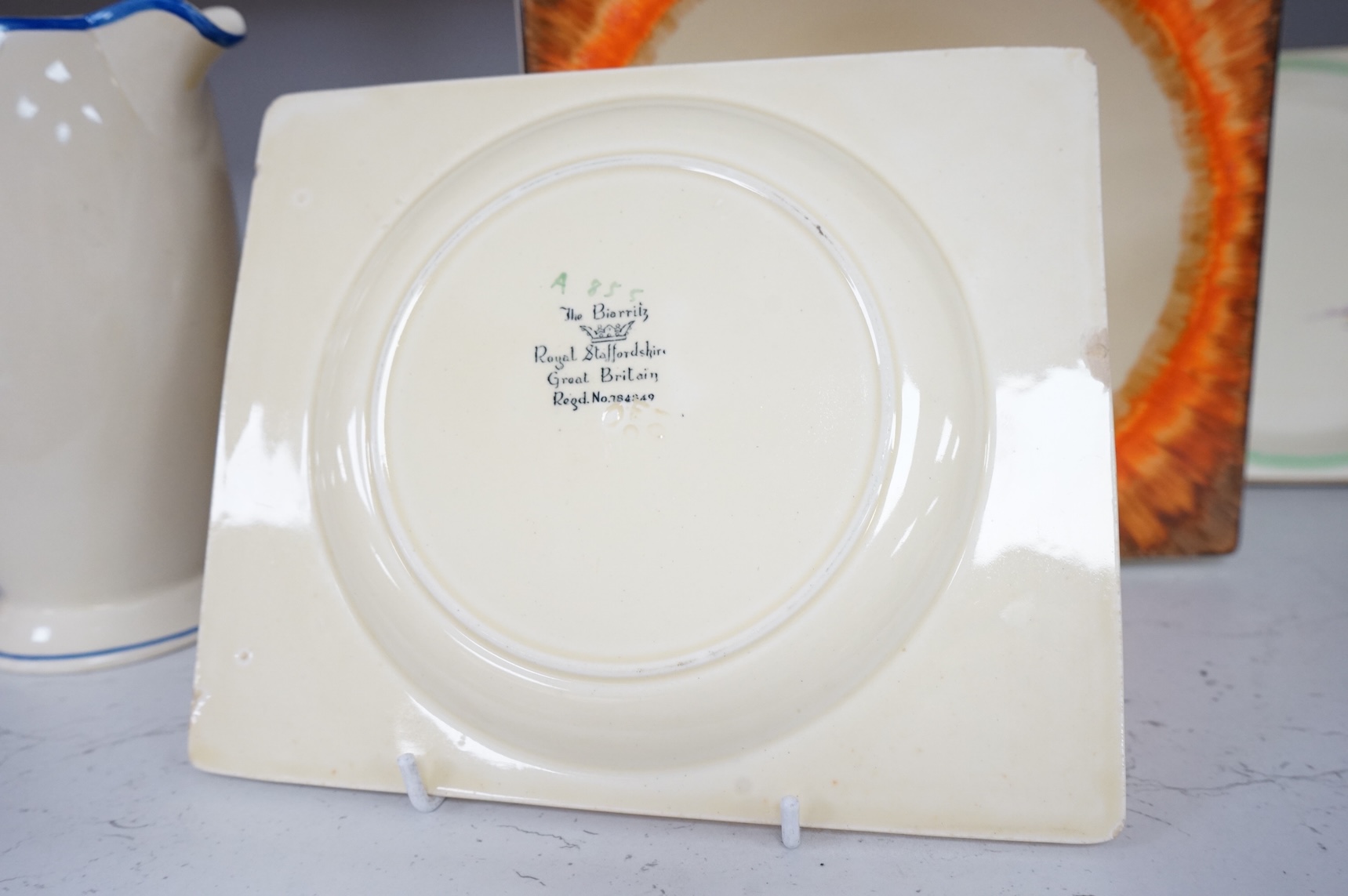 Three Clarice Cliff Bizarre ‘Biarritz’ dishes and a Wilkinson floral jug, largest 23cm wide